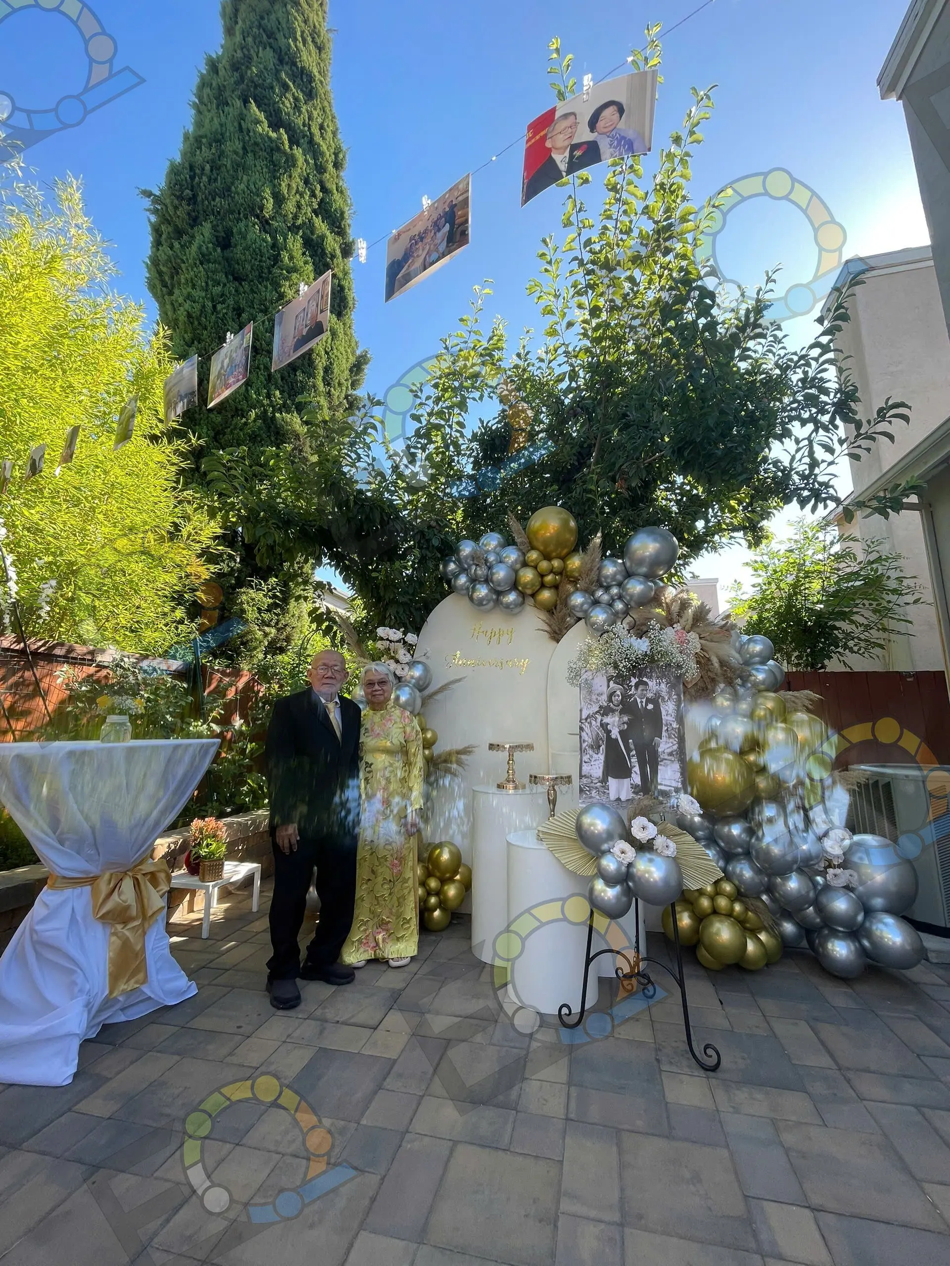 A gold and silver balloon arch set up in a garden