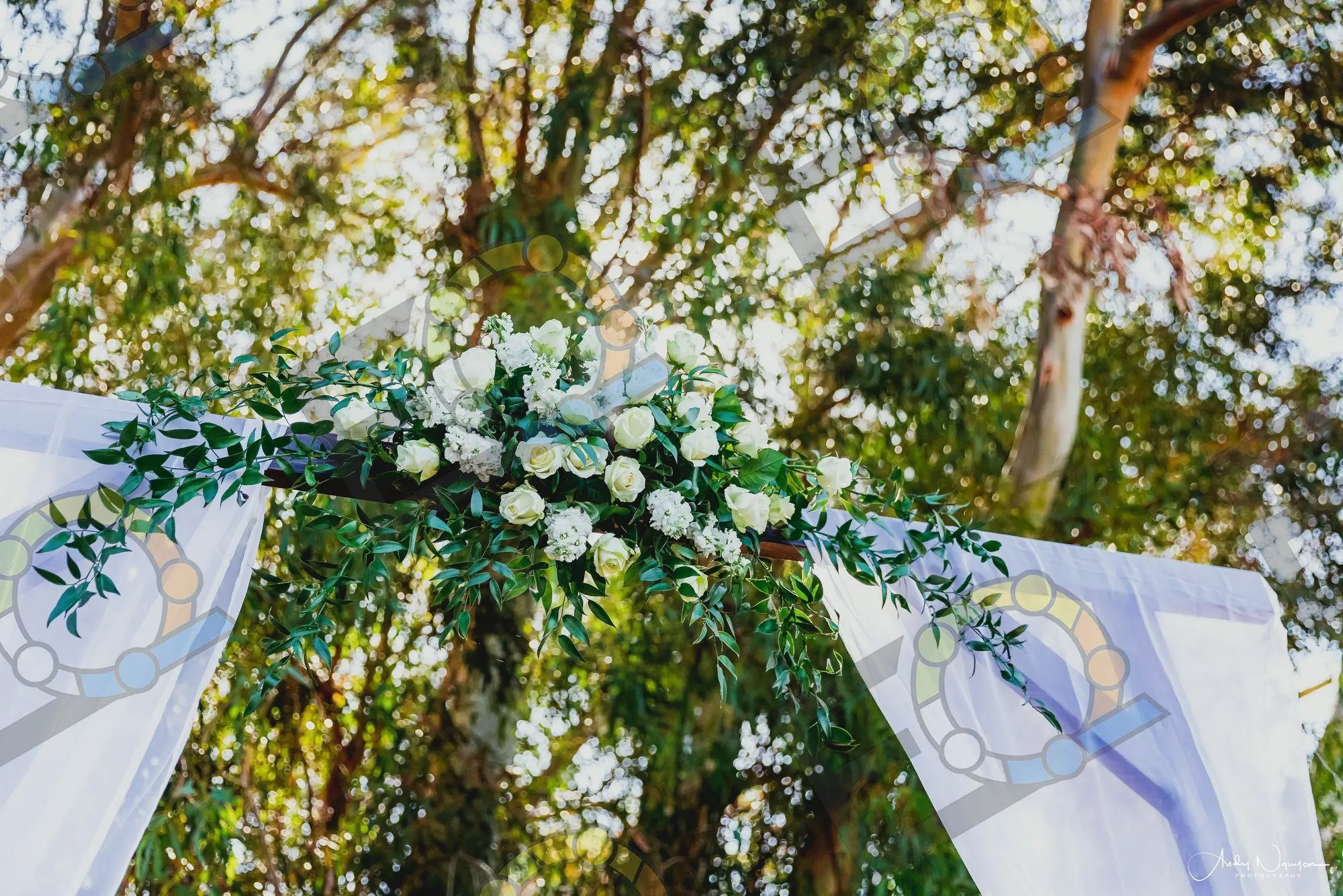 Ceremony arch florals set against mature trees