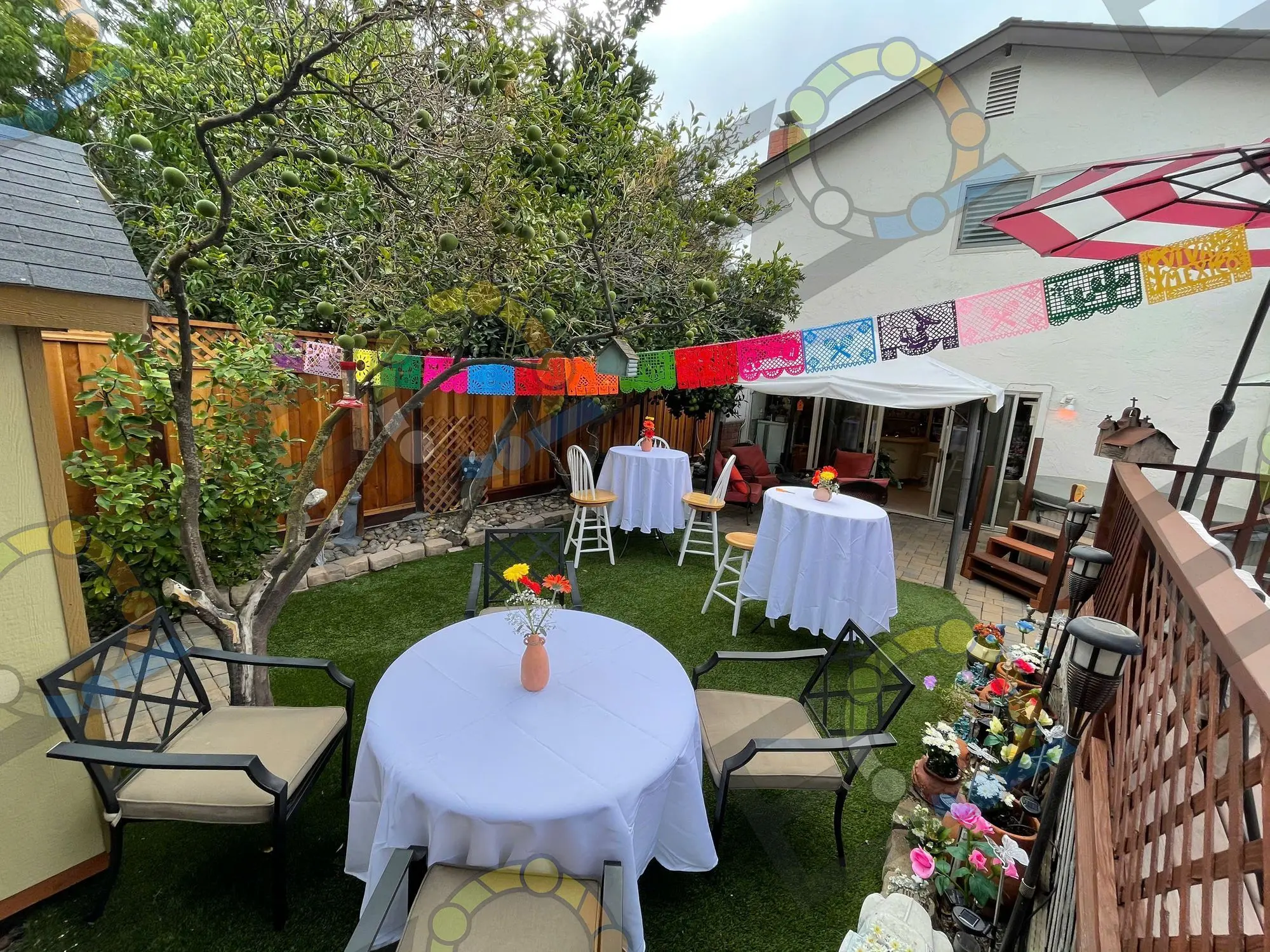 A round table with a floral centrepiece under colourful bunting