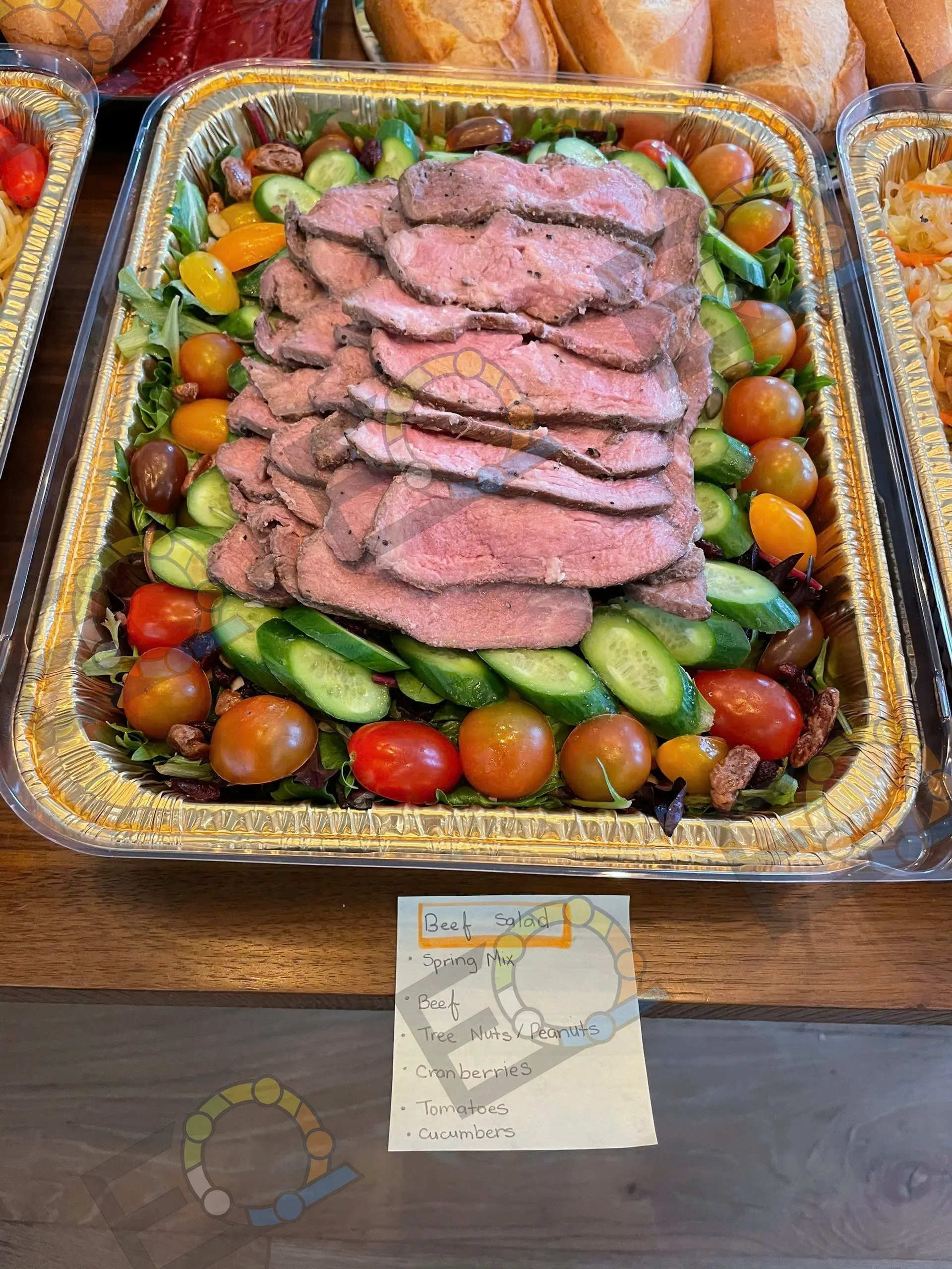 Sliced beef arranged with cherry tomatoes and cucumber on a serving tray