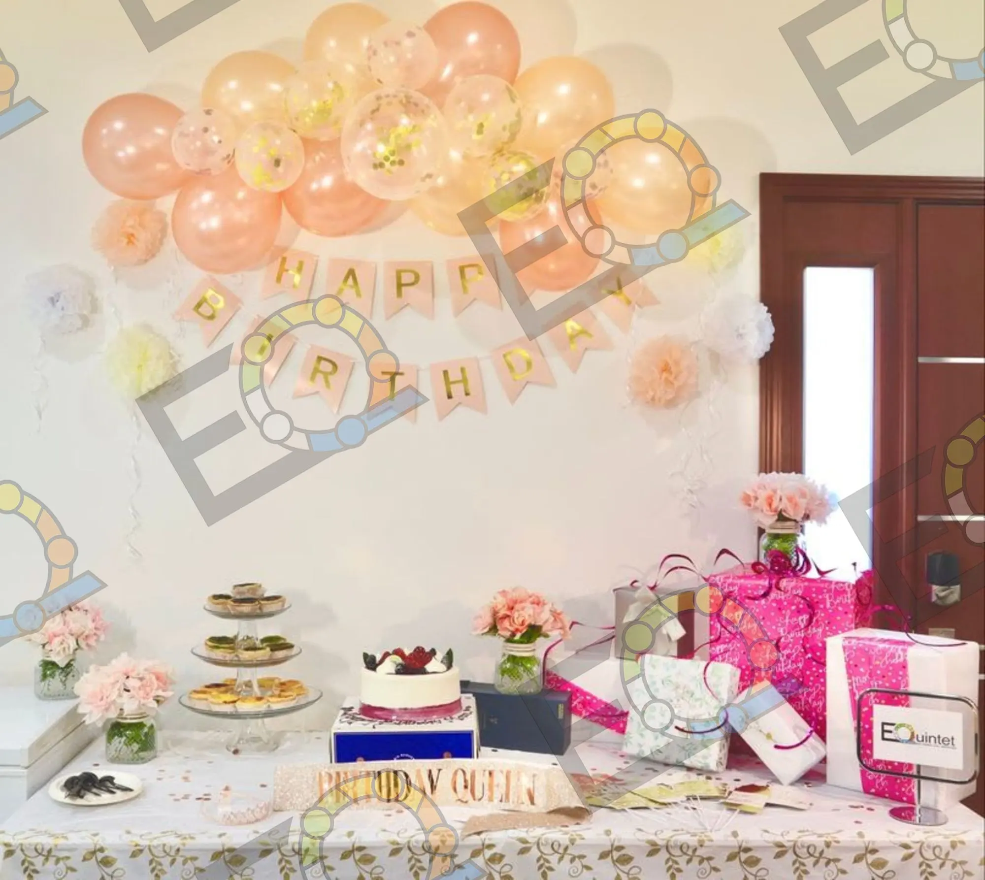 Peach balloon garland above a birthday dessert table