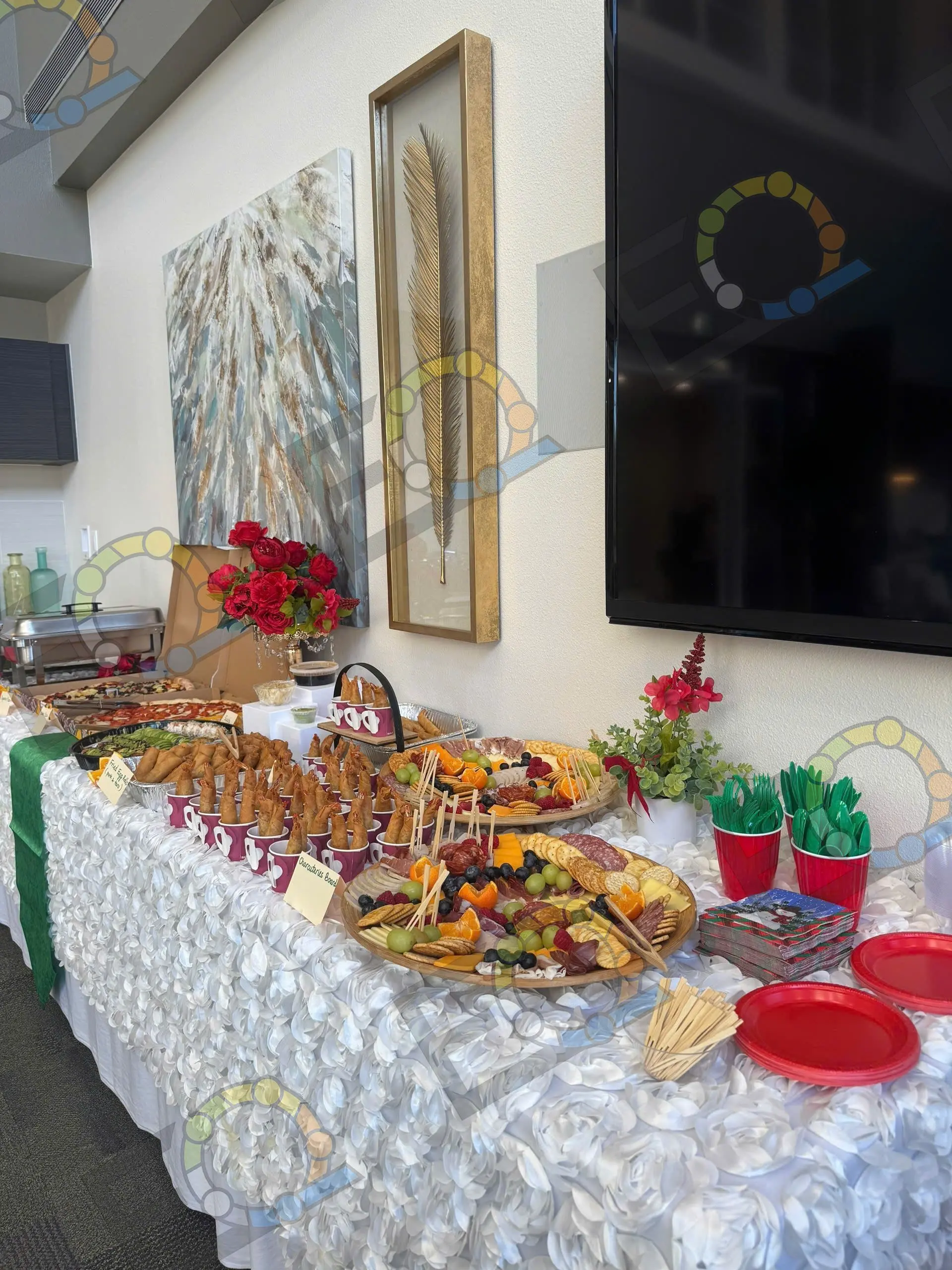 A long holiday buffet of platters and skewers on a rosette-linen table