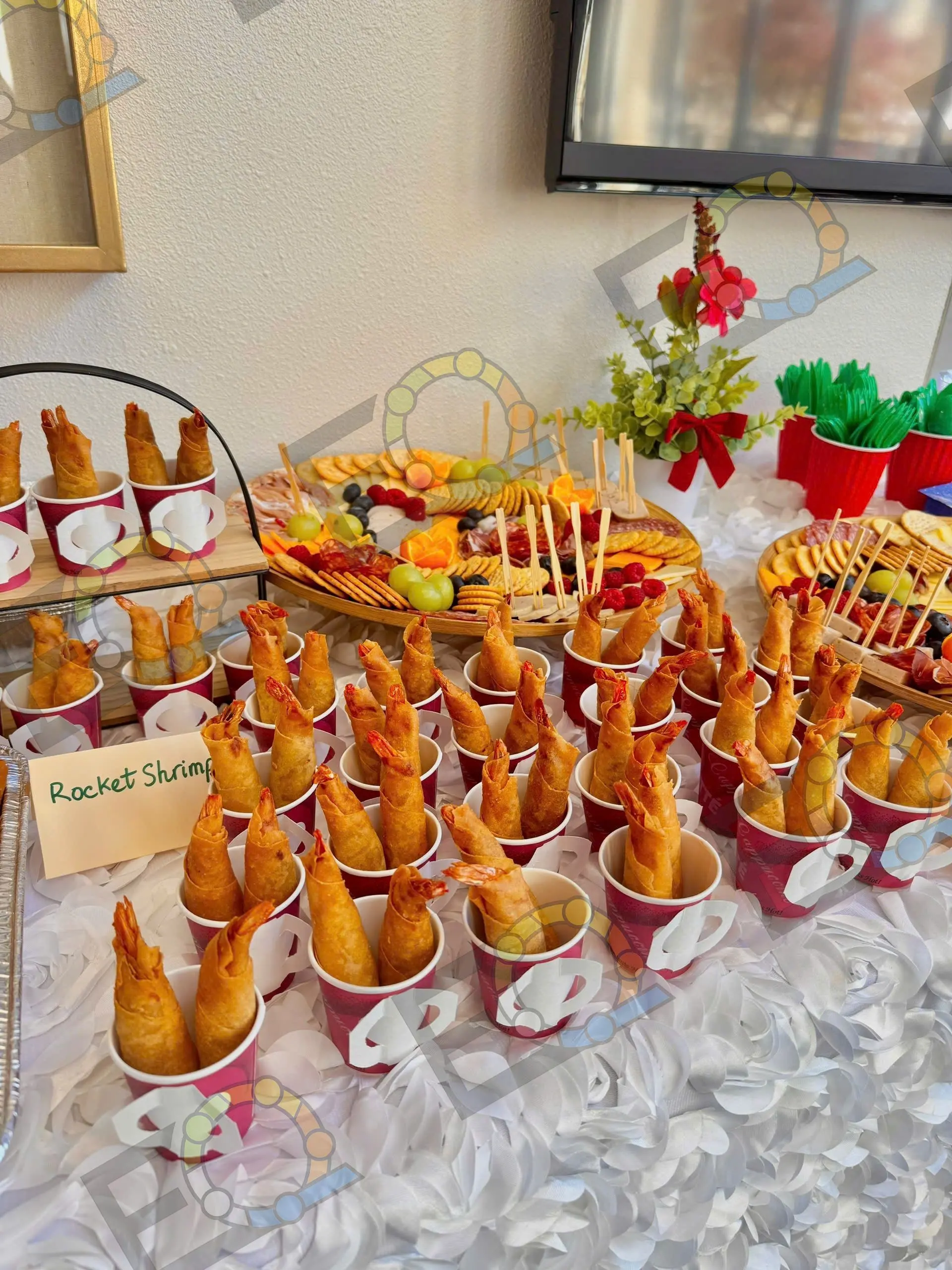 Rocket shrimp served upright in paper cups along a labelled buffet