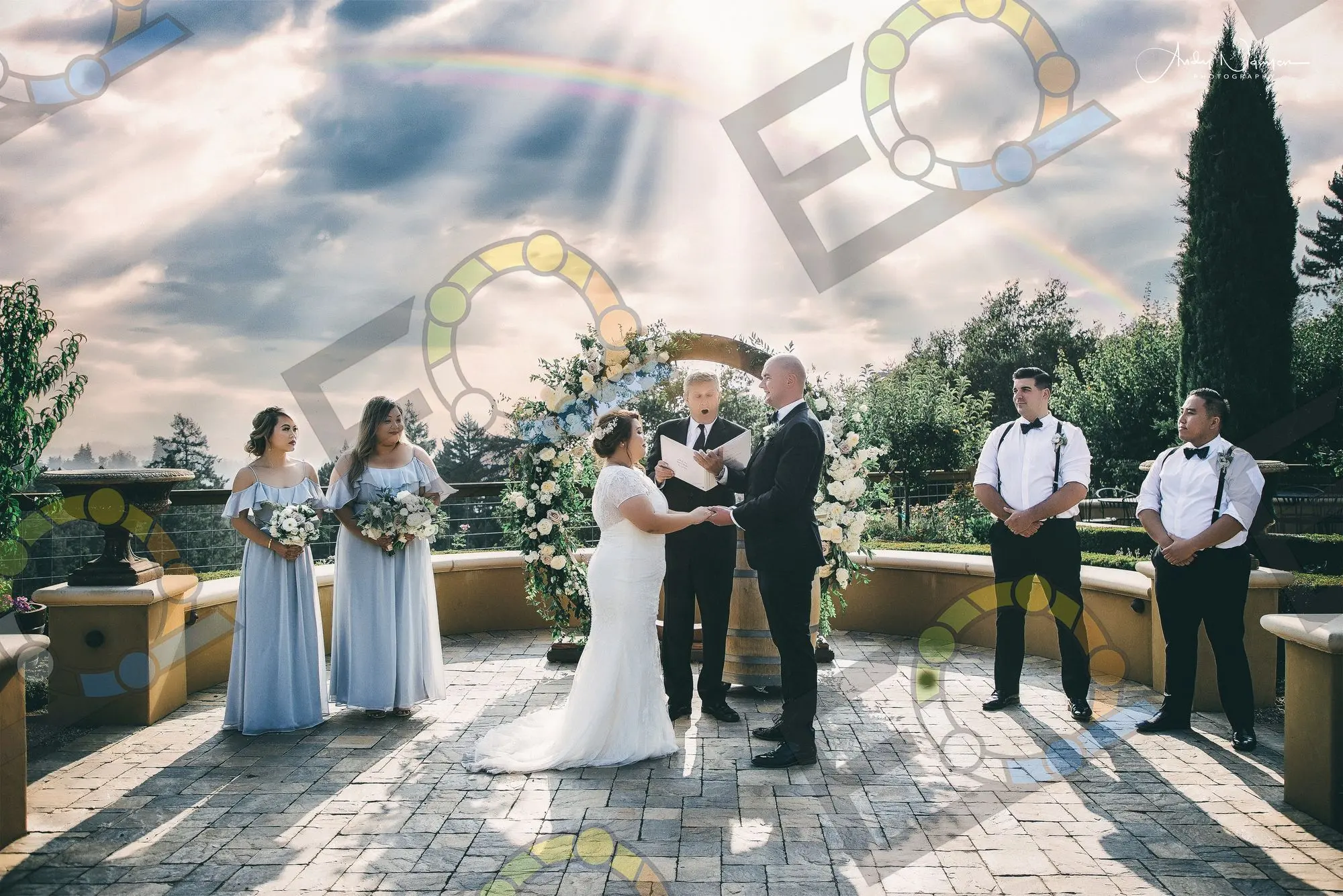 A wedding party gathered at a floral ceremony arch