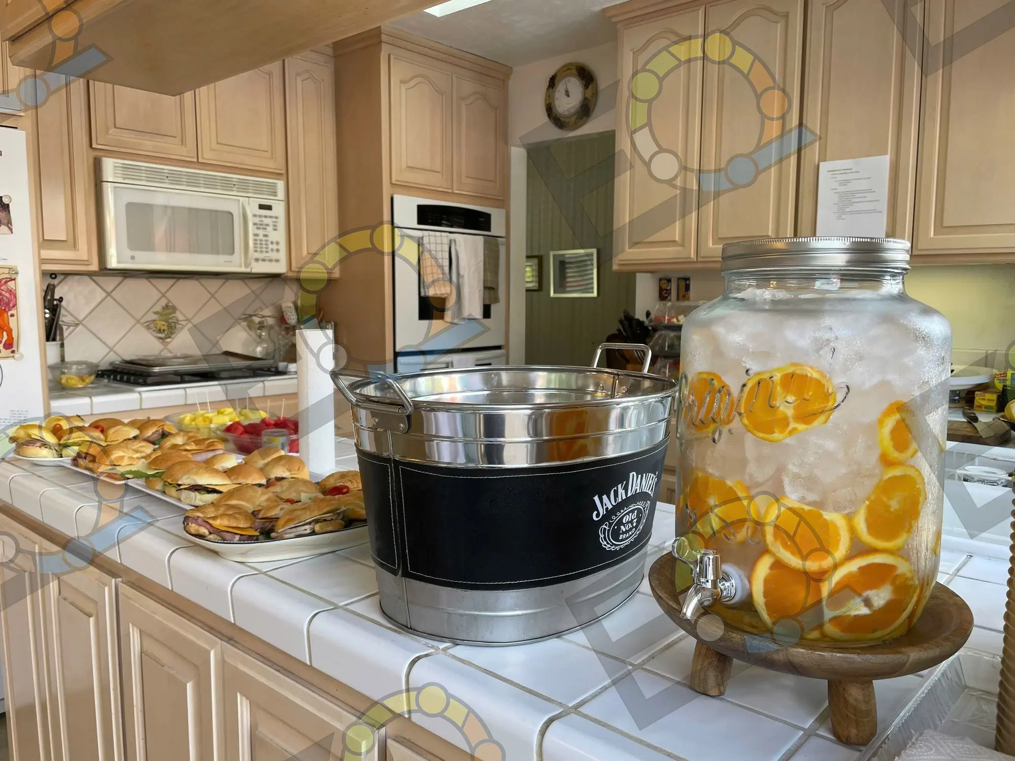 A citrus water dispenser and pastries on a kitchen counter