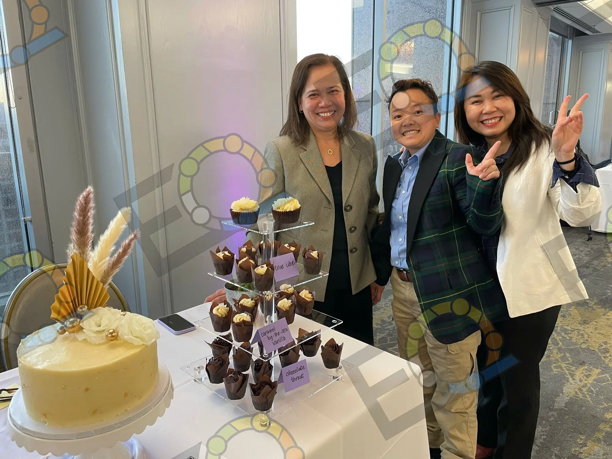 Guests beside a cupcake tower and celebration cake