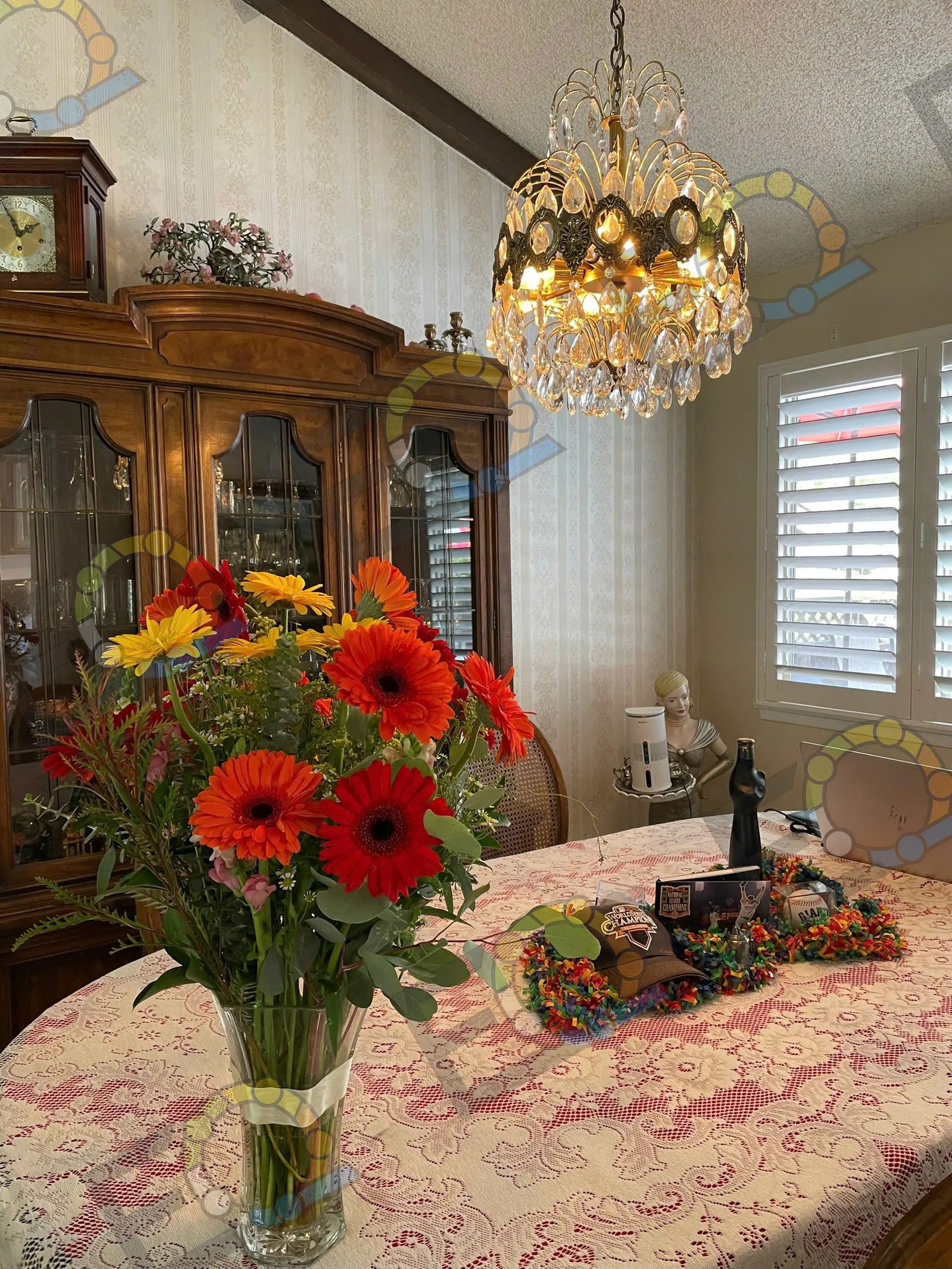 Red and yellow gerberas beneath a crystal chandelier