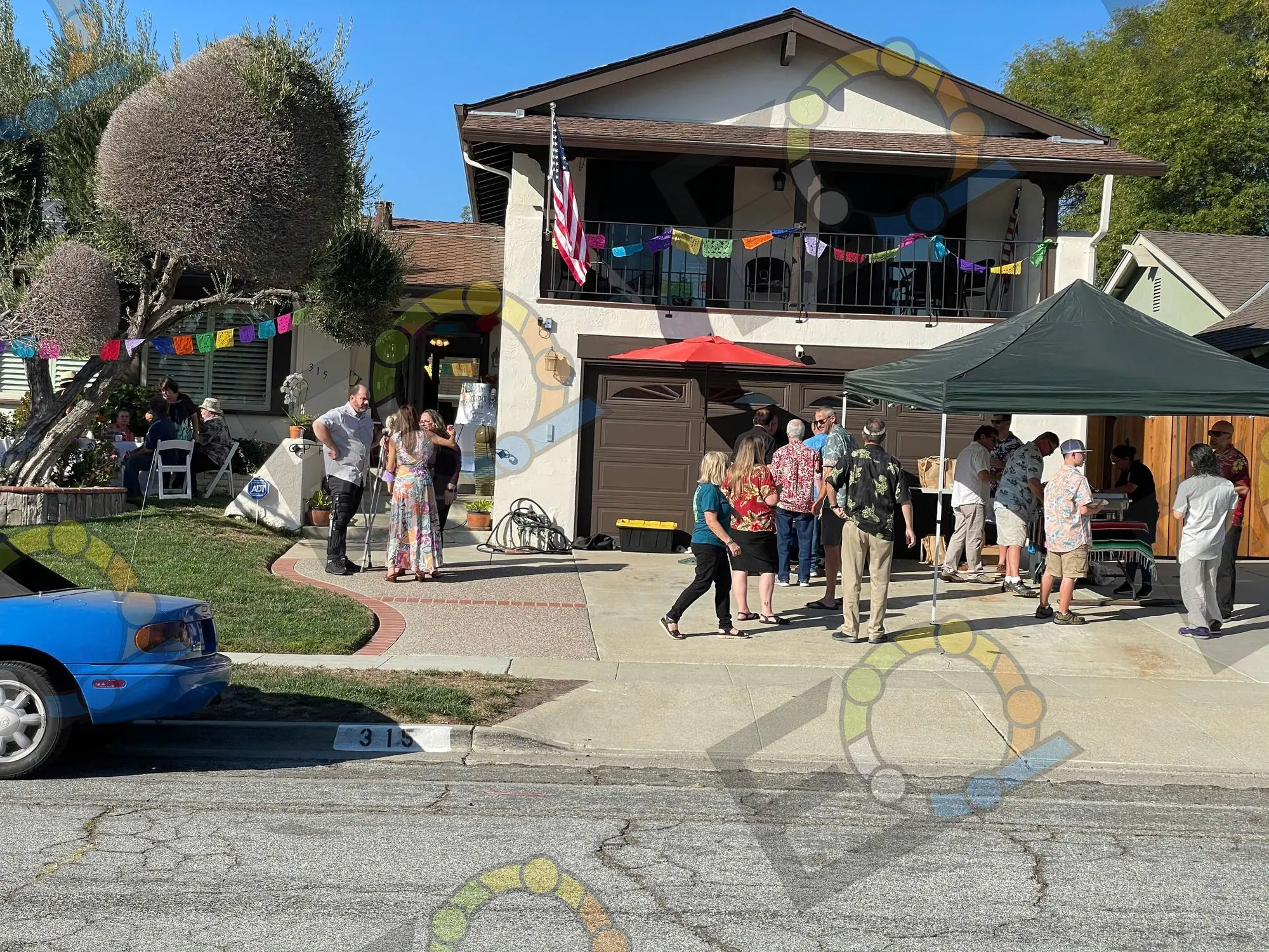 A driveway gathering under a canopy and bunting