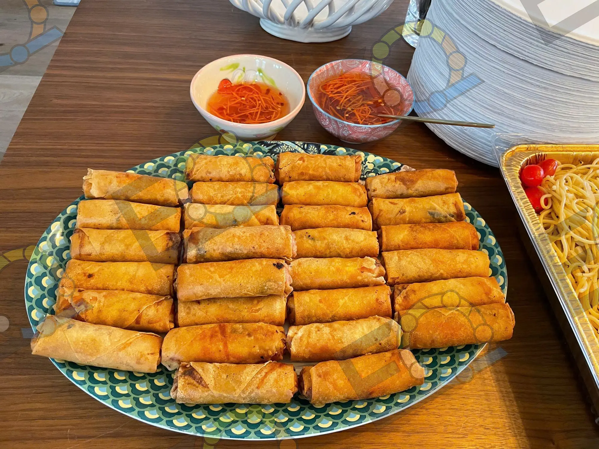 A platter of crisp egg rolls with dipping sauces