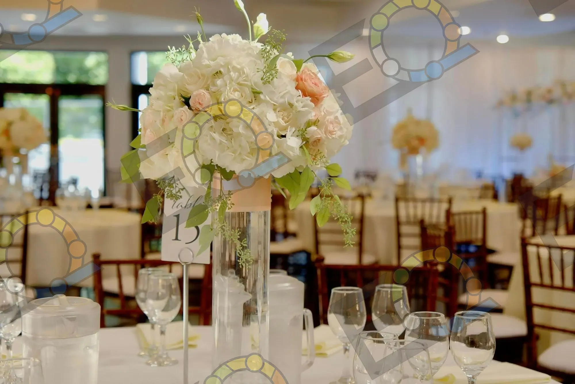 Tall white floral centerpiece on a set dinner table
