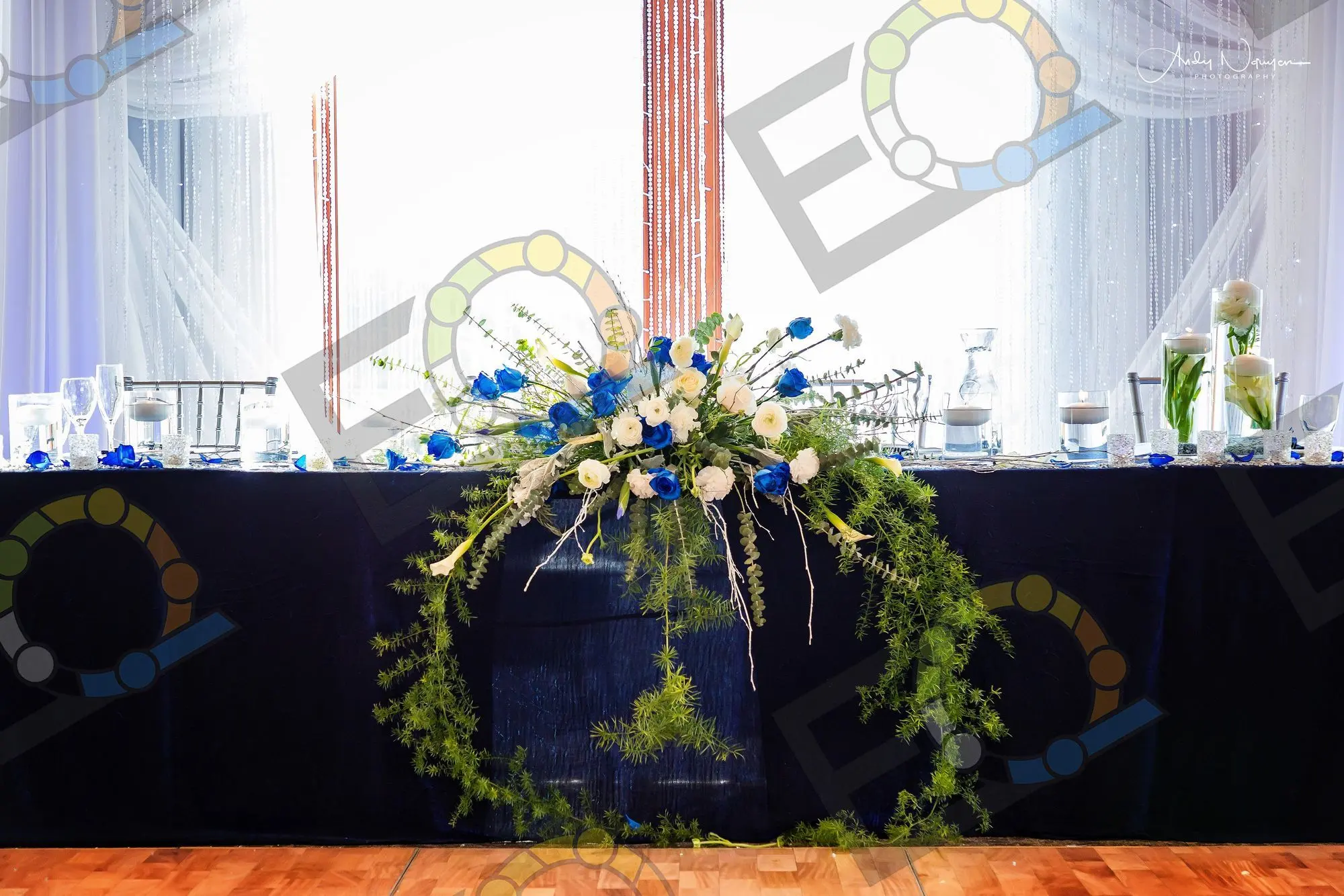 A head table dressed with a blue and white floral swag