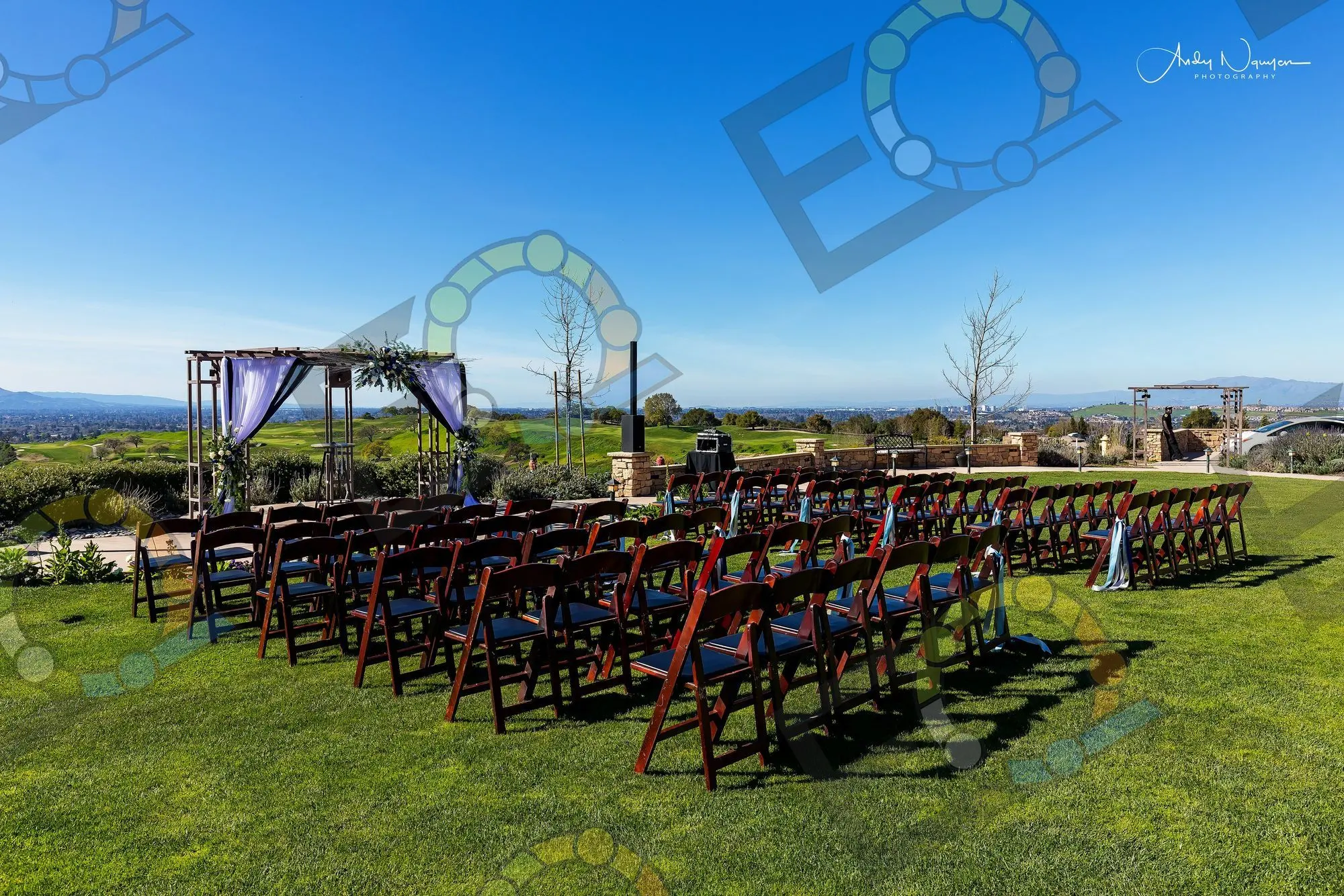 A hilltop ceremony arch with rows of chairs