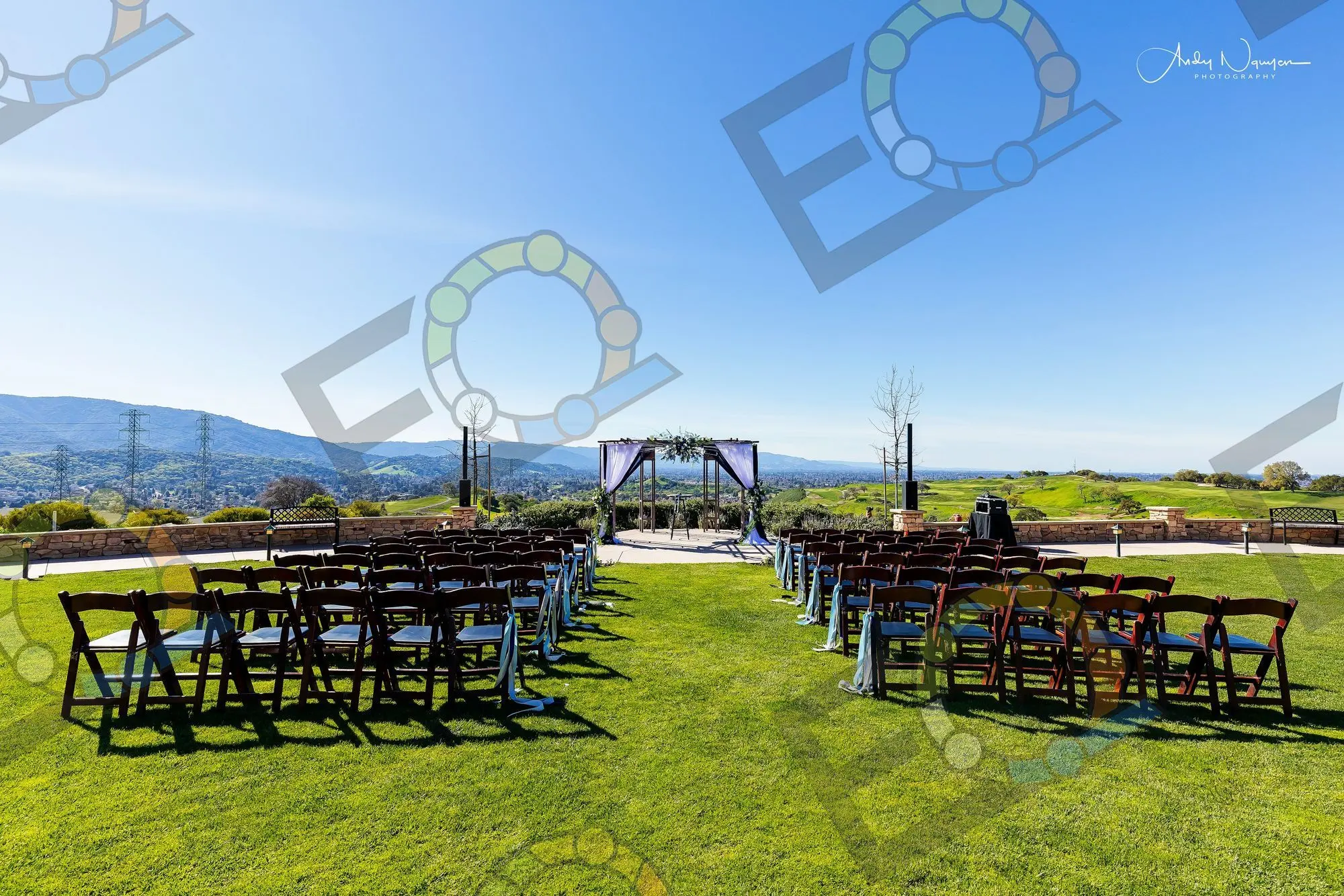 Ceremony chairs set on a hilltop lawn above a valley