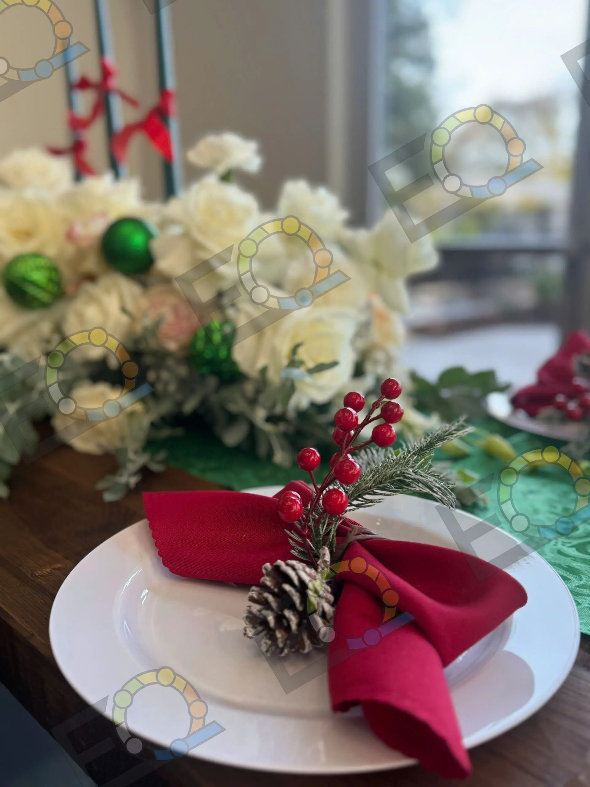 A red napkin and pine cone on a holiday place setting