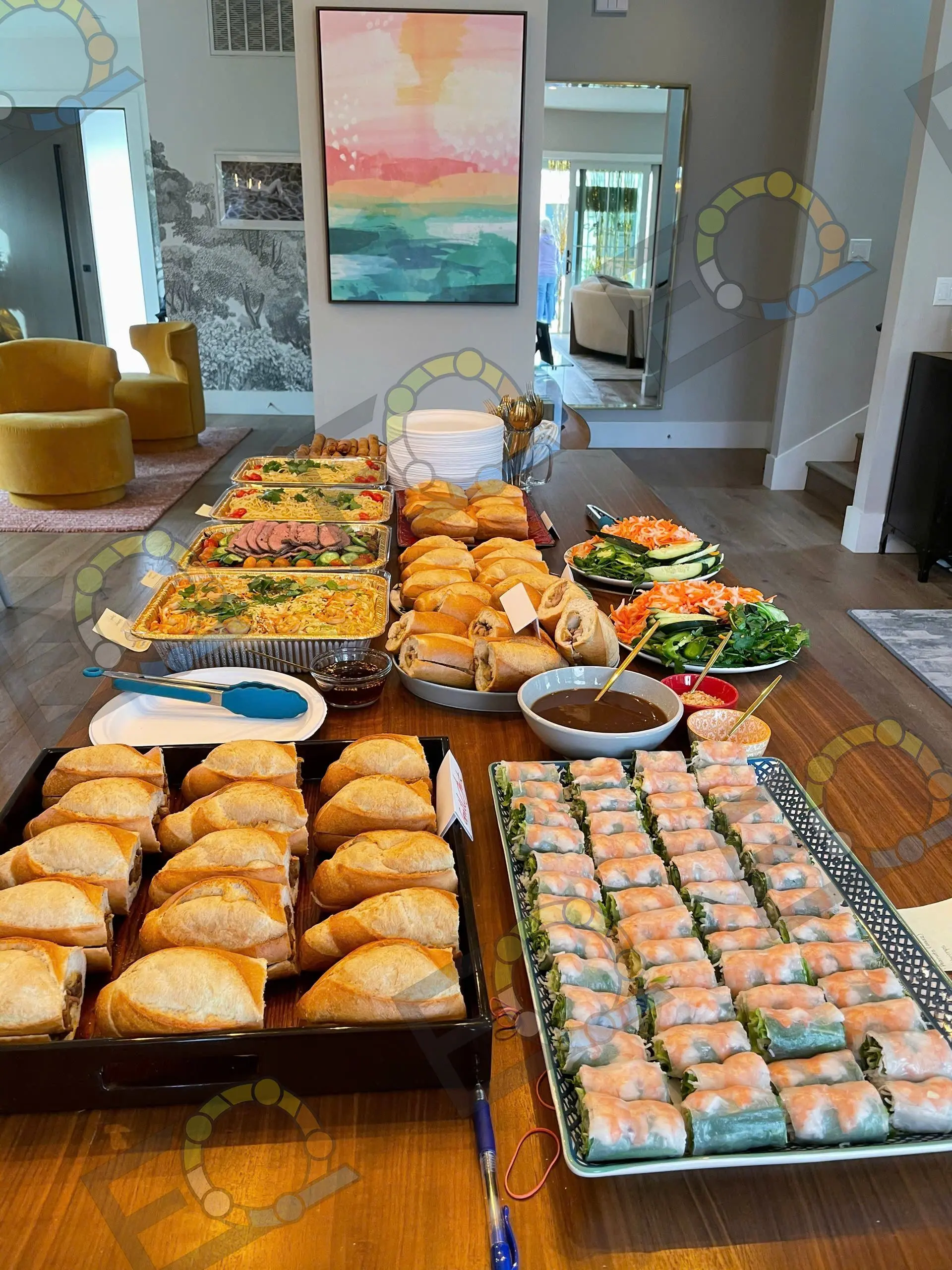 A buffet of banh mi, spring rolls and salads set indoors