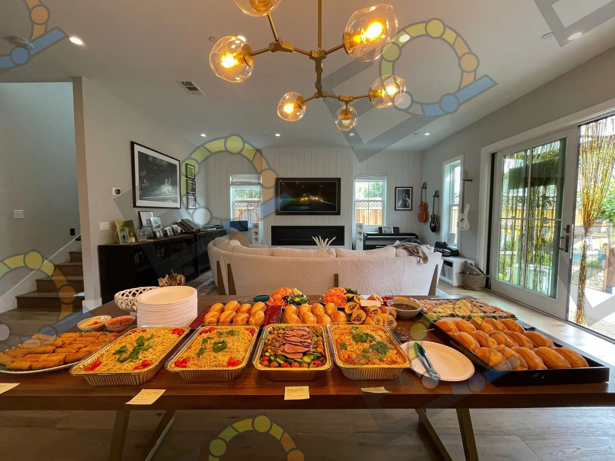 A buffet laid on a long wooden table beneath a brass chandelier