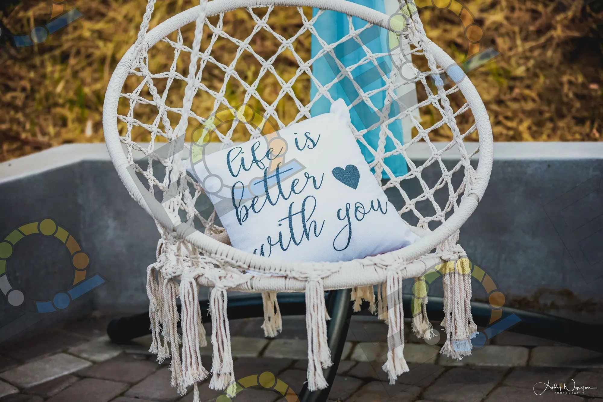 A macrame hanging chair with an embroidered cushion