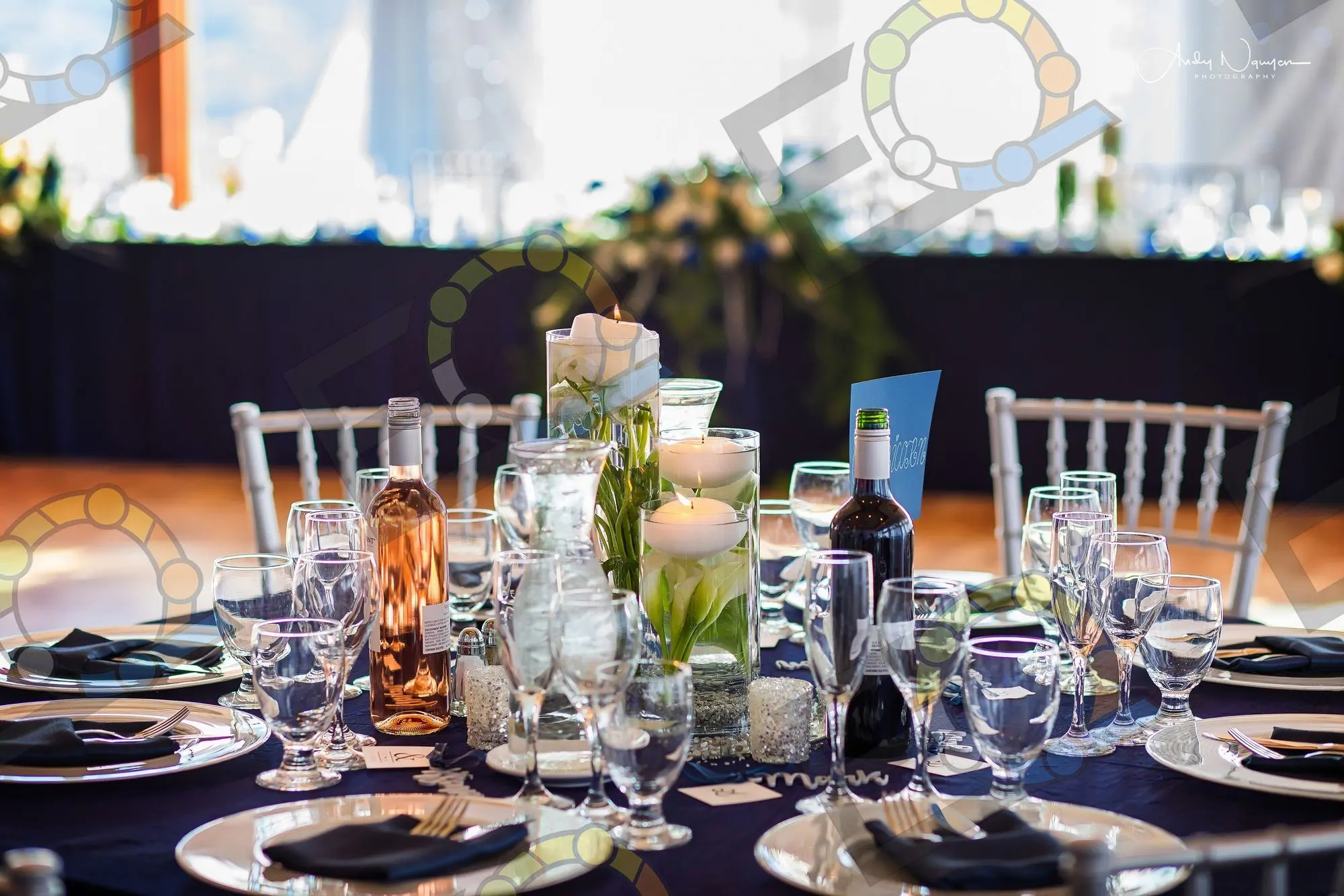 A navy head table lit with pillar candles