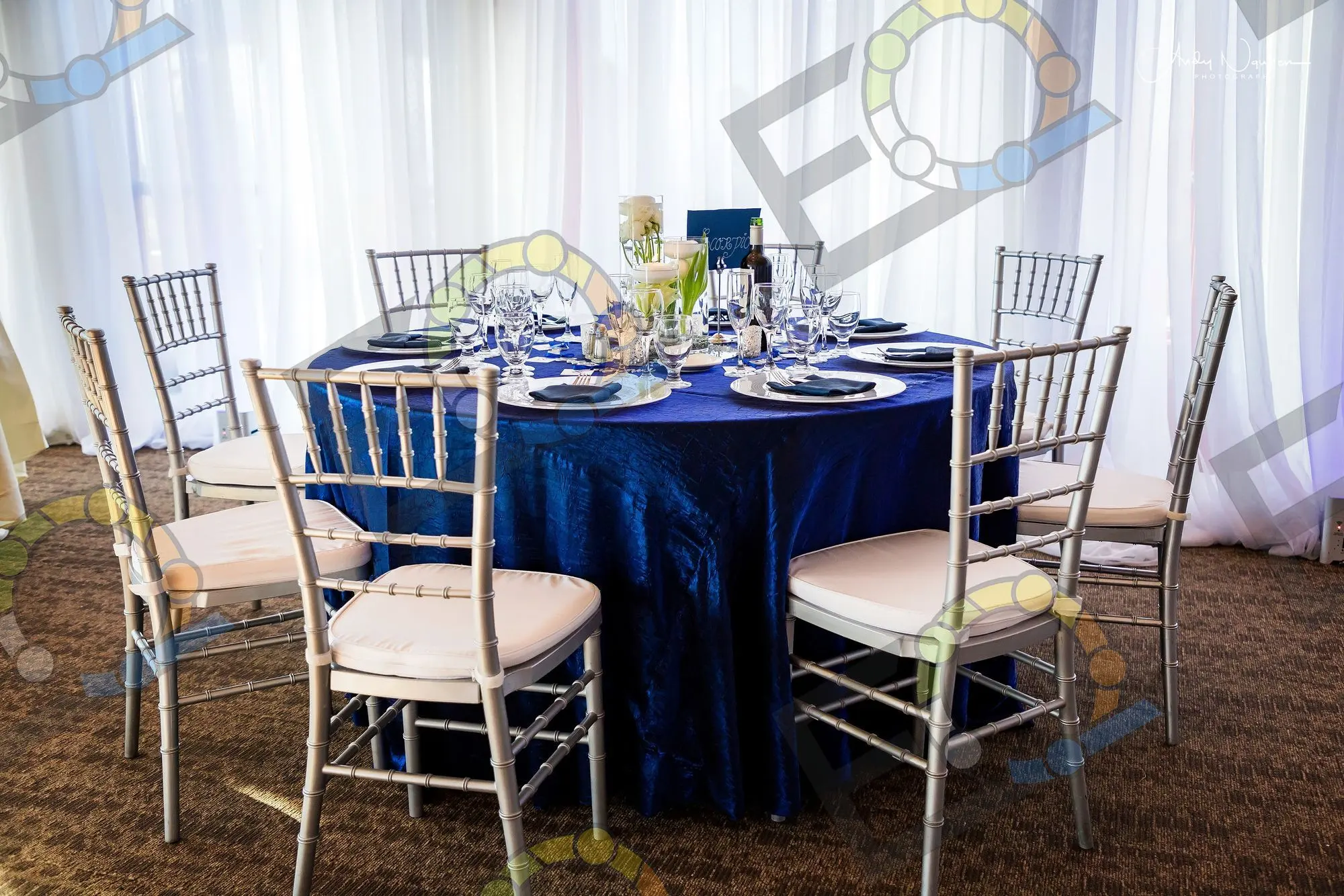 A navy round table with silver chiavari chairs
