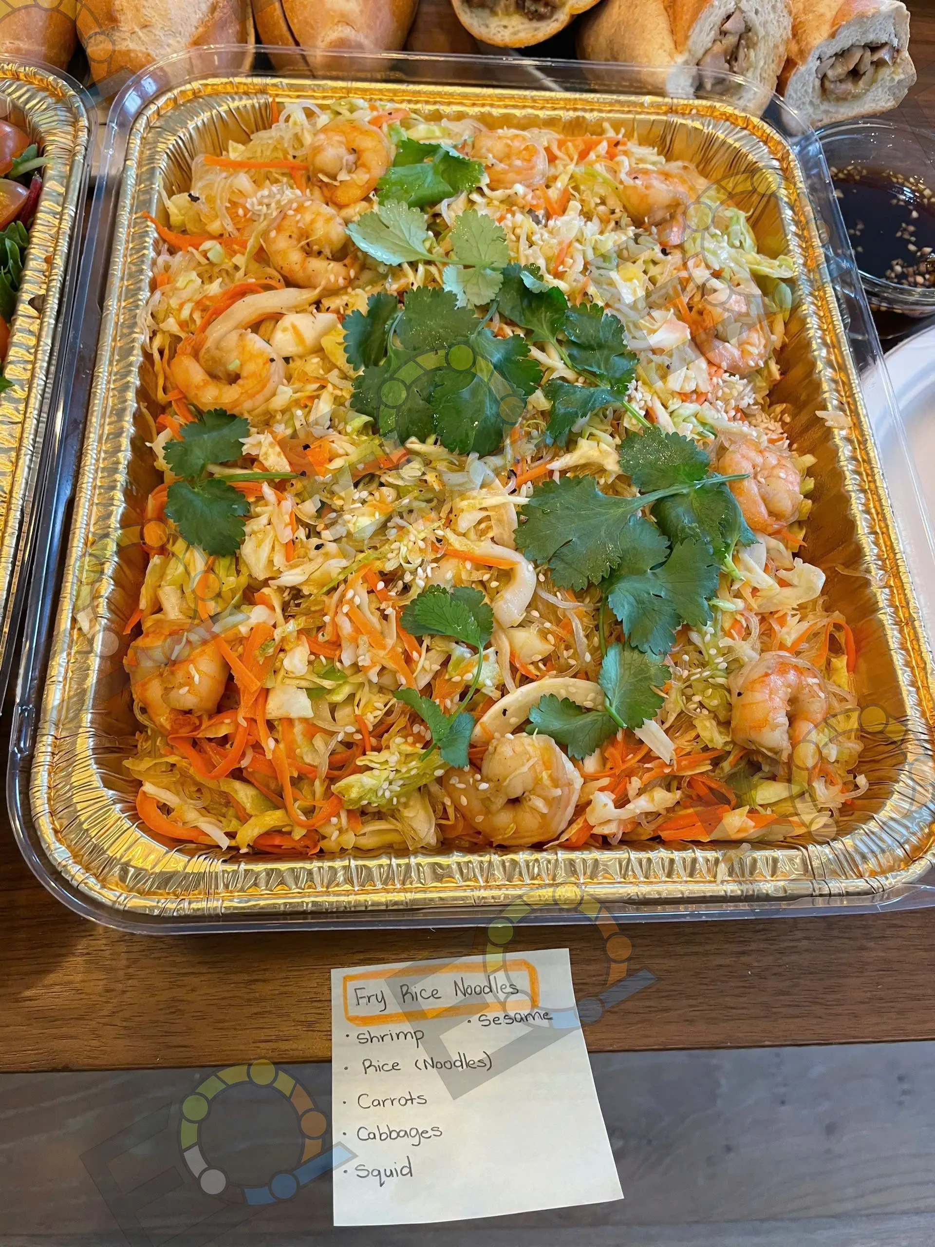 A tray of shrimp noodles garnished with coriander