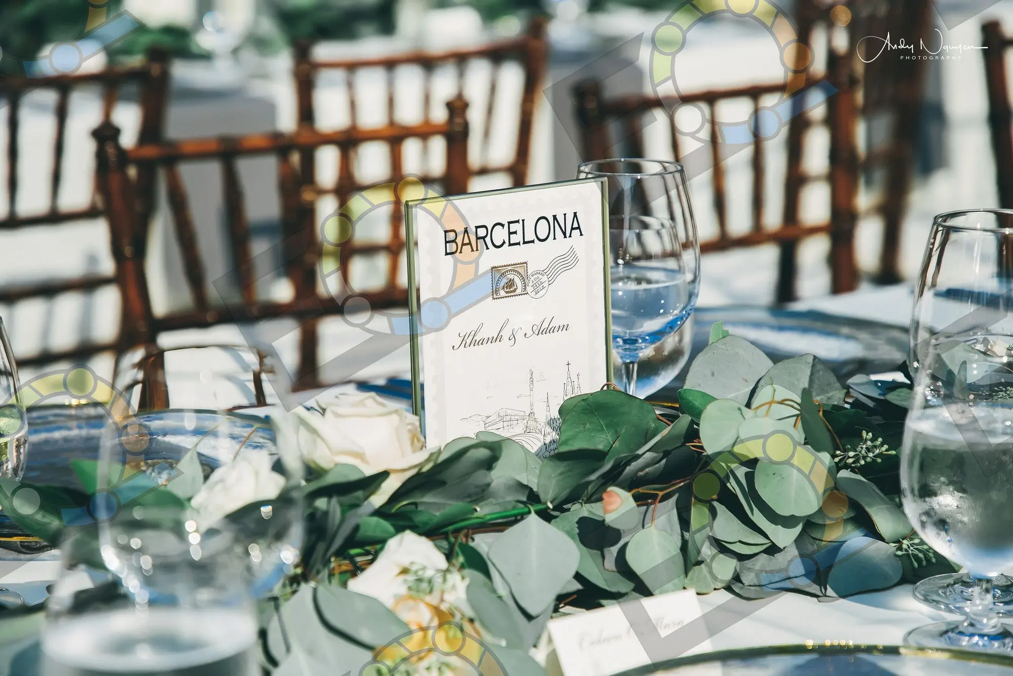 A named table sign set among eucalyptus and glassware