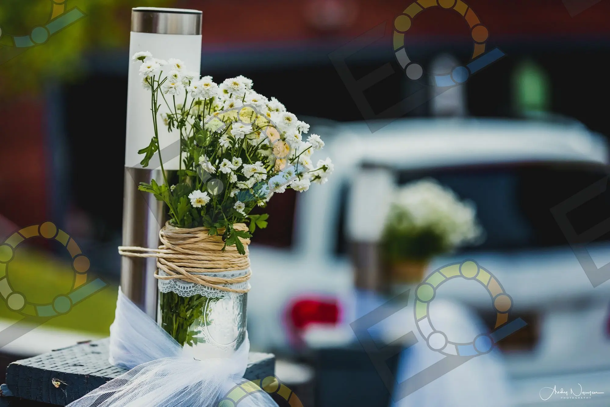 White blooms wrapped in twine on a ceremony post