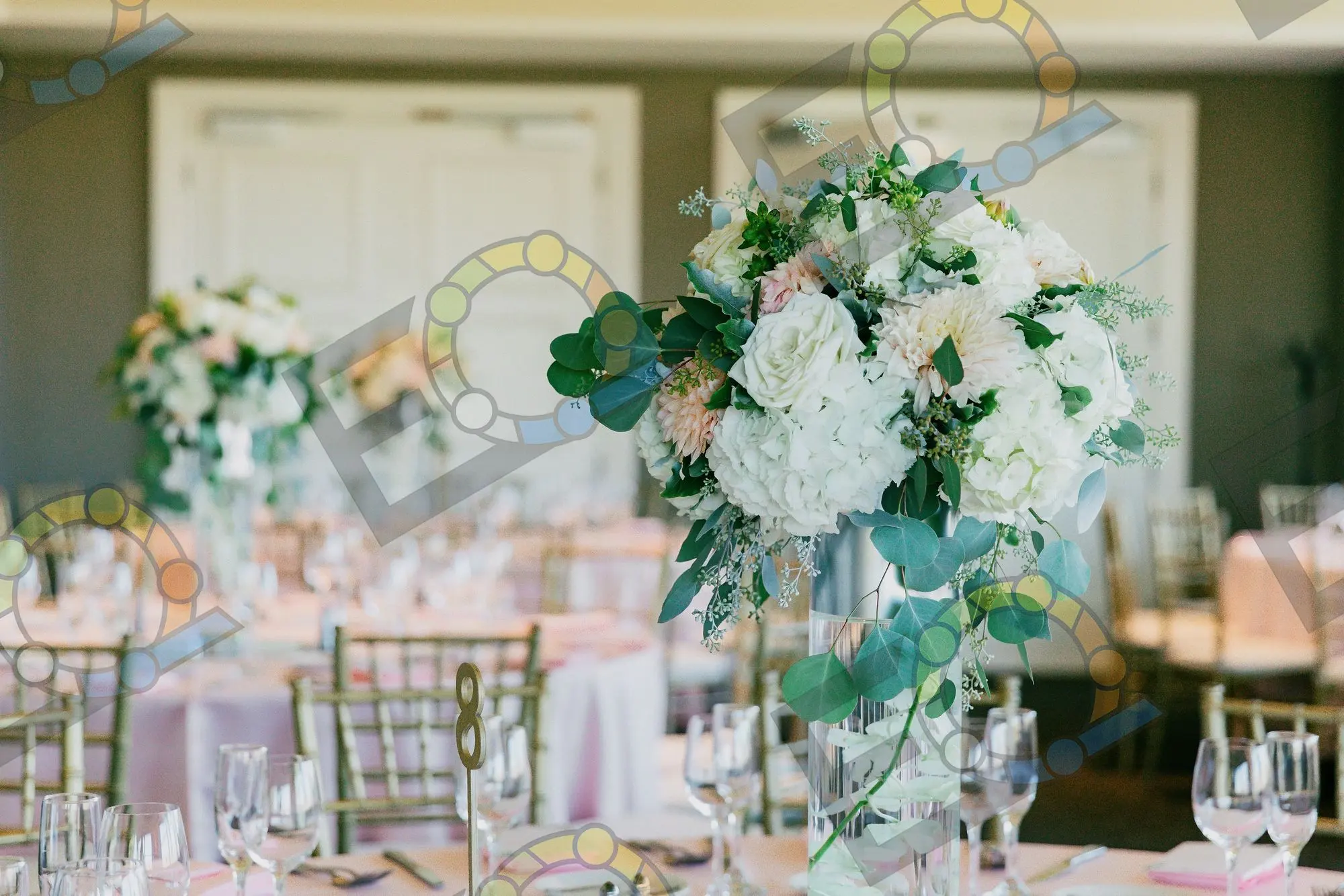 White blooms and eucalyptus arranged on a reception table